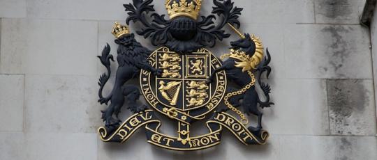 Blue and gold emblem and name on the Royal Courts of Justice building